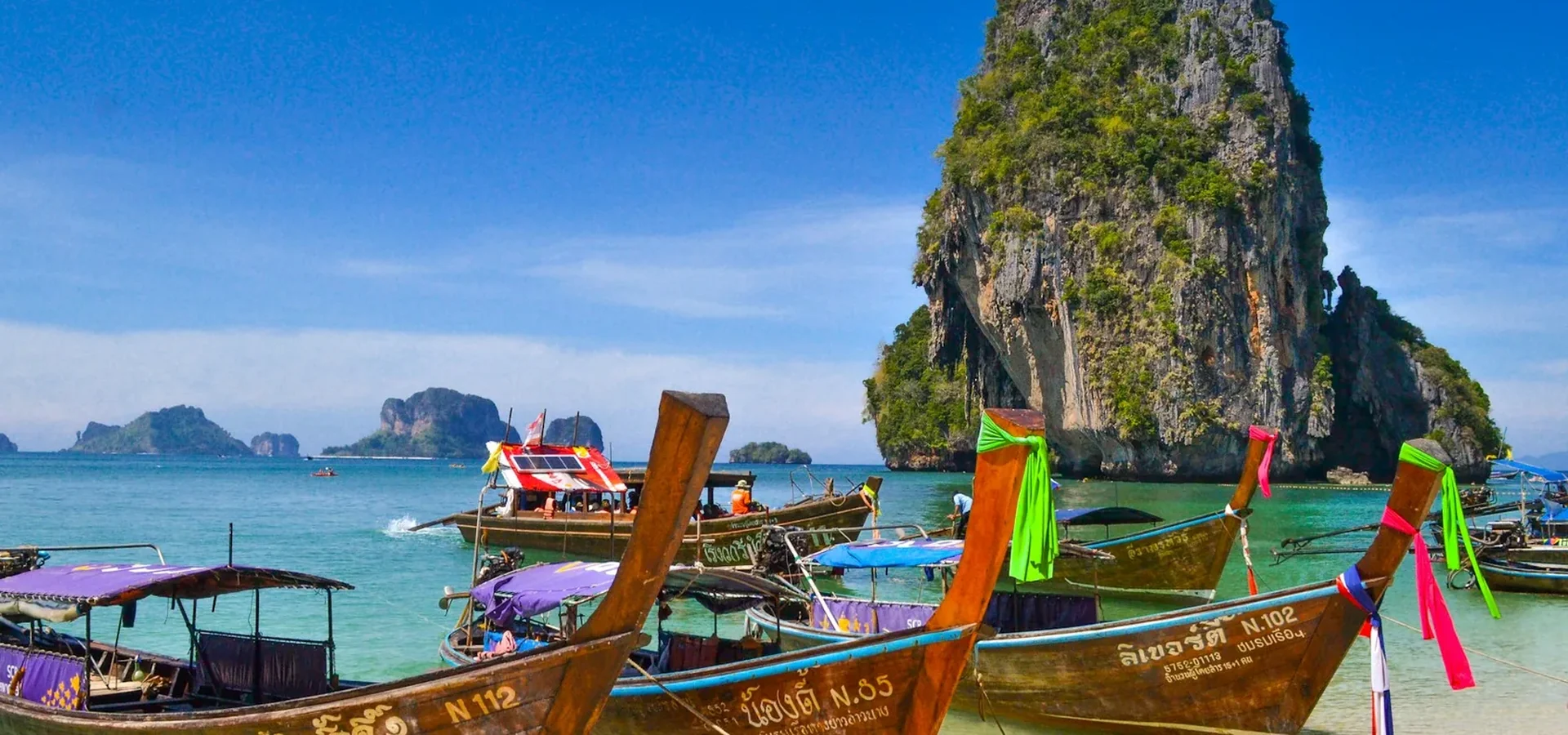 Long-tail boats and limestone cliffs in southern Thailand